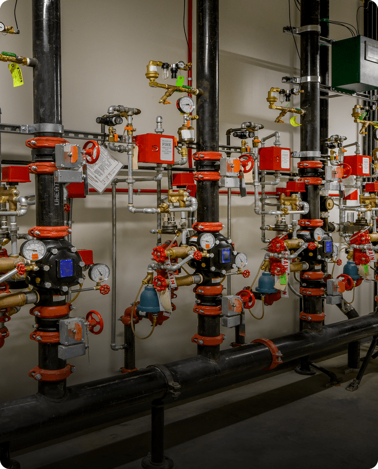 Industrial piping system with red valves and gauges.