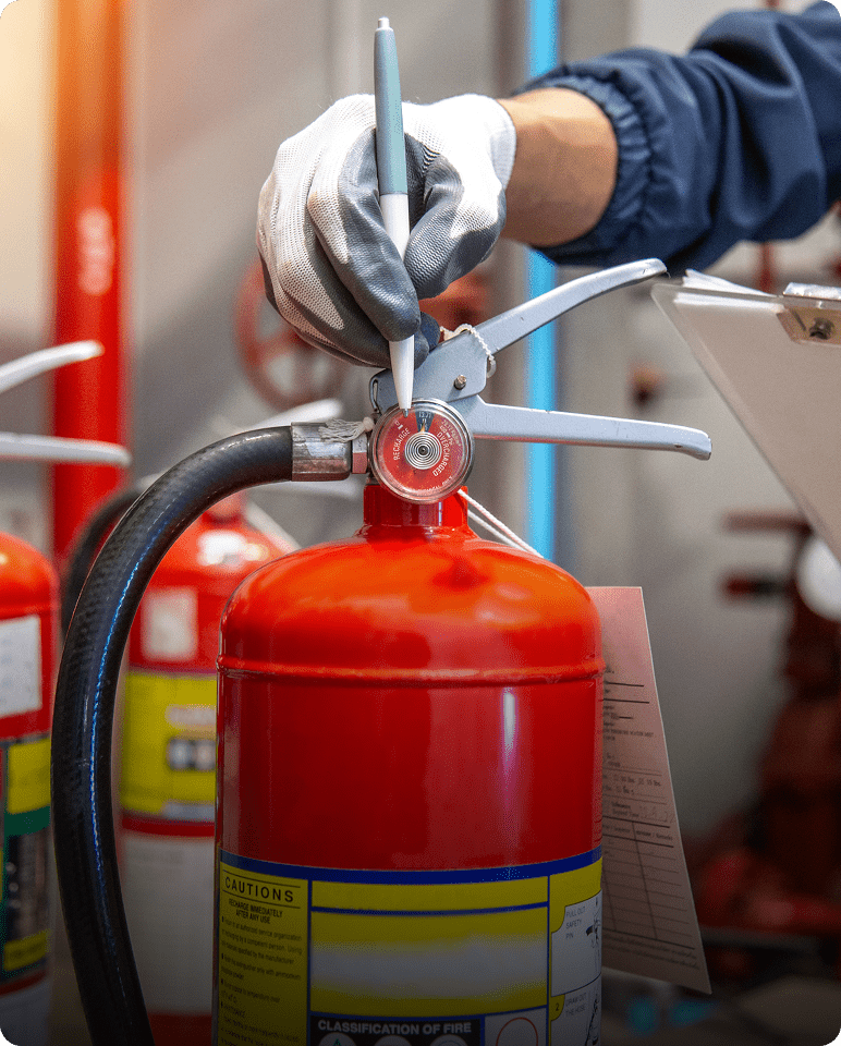 Inspecting fire extinguisher with gauge and clipboard.