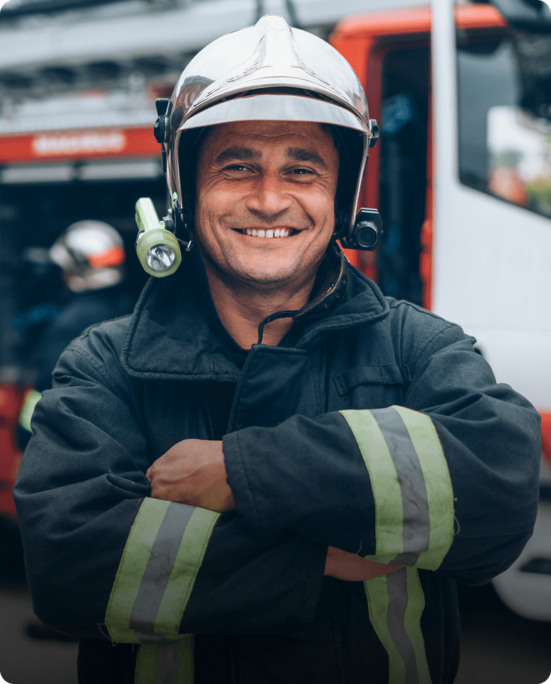 Smiling firefighter in uniform and helmet.